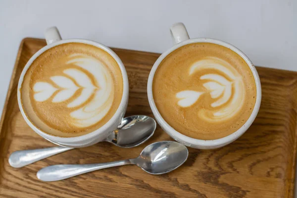 Zwei Weiße Tassen Cappuccino Auf Einem Holztablett Nahaufnahme — Stockfoto