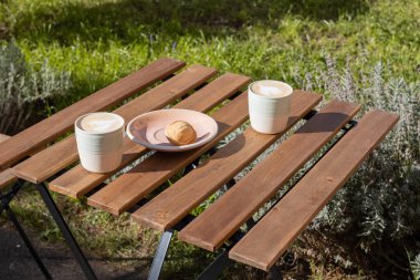 Kapuçino, fındıklı tatlı ve konsantre süt. Açık kafe masası.