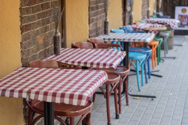 Açık bir kafede kareli masa örtüleriyle kaplı masalar