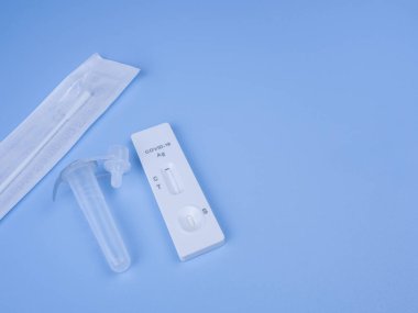 İzole edilmiş mavi arka planda kendini test etmek için antijen test kiti (ATK). Covid-19 antijen test kiti. Boşluk alanını metin için kopyala.