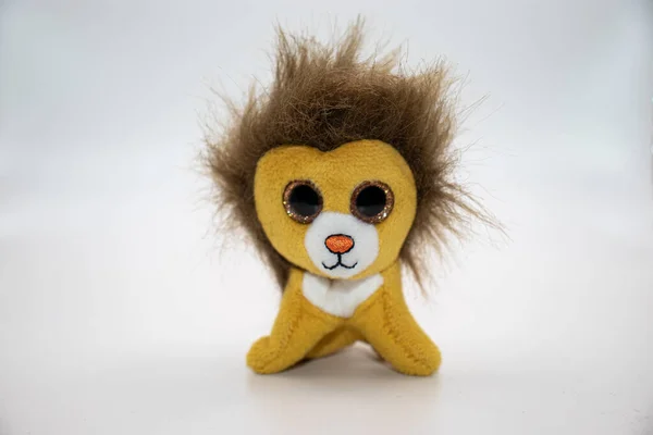 Küçük oyuncak aslan yavrusu beyaz arkaplanda izole edilmiş.