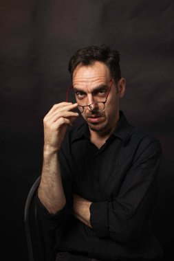 Oturmuş gözlüklü bir adamın portresi.