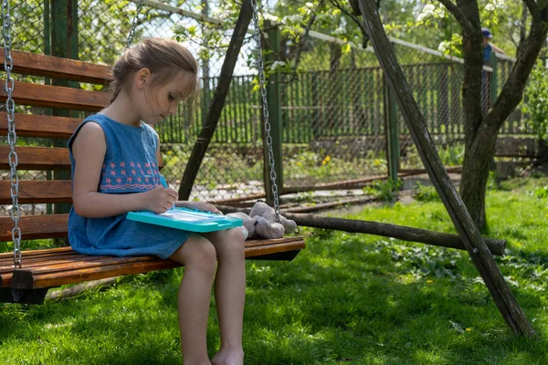 Adorable Little Girl Concentrated Learning Write While Sitting Swing Sunny — Stok Foto