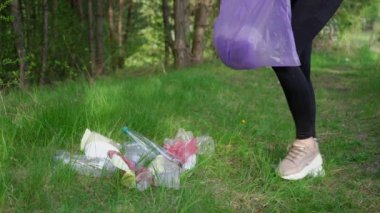 Kız çöpleri topluyor, bloglama konsepti yapıyor. Çöp torbasında çöp topluyorum. Çevre plastik kirliliği. Doğa temizliği, gönüllü ekoloji yeşil kavramı. Yüksek kalite 4k görüntü
