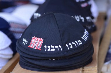 Geleneksel siyah Yahudi kipa kazıkları. Kippah 'ın sözleri pazarda satılmak için dua ediyor. Tanrı bizim Tanrımızdır, Tanrı tektir.
