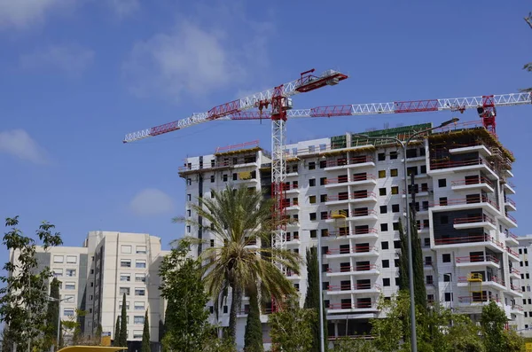 İsrail 'de modern bina. İnşaat vinci ve iş akışı. Parlak mavi gökyüzü ve beyaz yeni ev