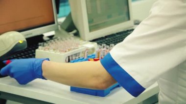 26.02.2021 Kyiv. Ukrayna - PCR Test Covid-19.Kan tüpleri test ediliyor. Kadın doktor test tüplerini laboratuvarda sınıflandırıyor. antikor testi