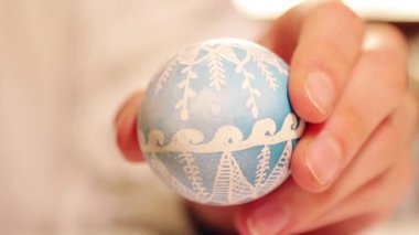 Happy Easter Holiday. Close-up hands paint and decorate eggs for a traditional spring dinner at home. traditional ornaments
