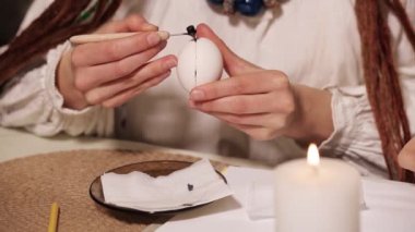 Mutlu Paskalyalar. Evdeki geleneksel bahar yemeği için yakın plan eller yumurta boyar ve dekore eder. Geleneksel süsler