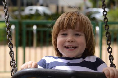 Mutlu küçük çocuk o gün parkta oynarken Avrupalı çocuk zincirli salıncakta sallanıyor..