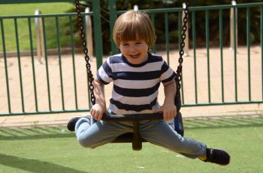 Mutlu küçük çocuk o gün parkta oynarken Avrupalı çocuk zincirli salıncakta sallanıyor..