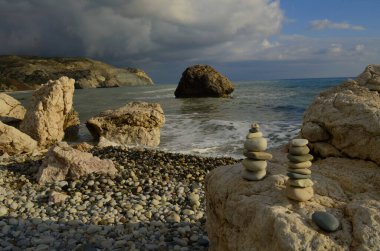 Paphos. Kıbrıs. Petra tou romiou. Afrodit 'in kayası. Denizin üzerinde dramatik fırtınalı bir gökyüzü. Denizde kayalar. Tanrıça Afrodit 'in doğduğu yer. Aşıklar için romantik plaj. Kış.