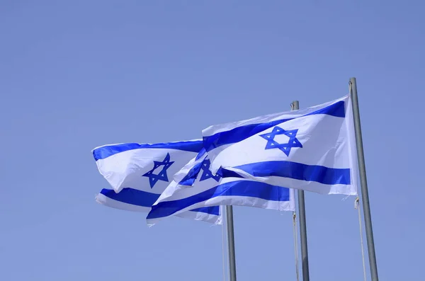 Flag of Israel. Israel flag close up shot on a background of blue sky. White and blue colors. Israel flag waving against clean blue sky