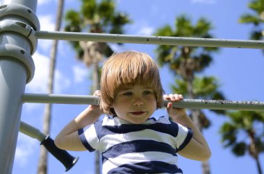 Parktaki küçük çocuk. Arka planda hindistan cevizi ağaçları var. Aile tatili, yaz eğlencesi