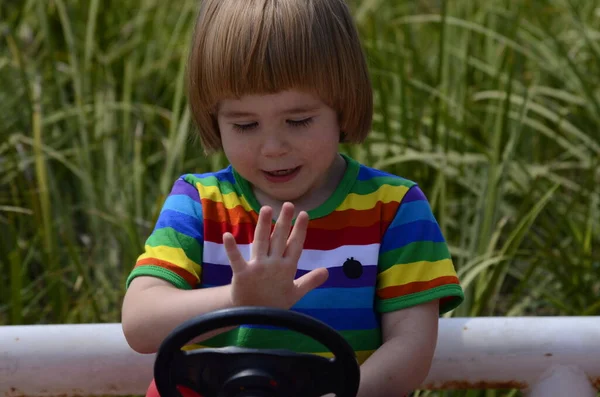 Niño Positivo Con Una Camiseta Colorida Con Arco Iris Sienta — Foto de Stock