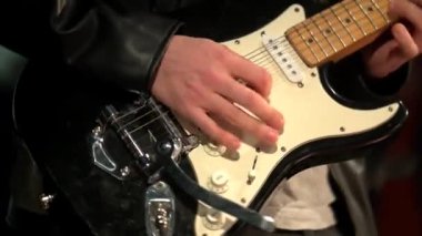 Elektro gitar çalan bir müzisyen. Parmaklarını boynuna yaklaştır. Rock, blues, Jazz tarzı konser, stüdyoda kayıt. Adam elektro gitar çalıyor. Sahnede gitaristin performansı. Yaşa 