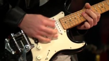 Elektro gitar çalan bir müzisyen. Parmaklarını boynuna yaklaştır. Rock, blues, Jazz tarzı konser, stüdyoda kayıt. Adam elektro gitar çalıyor. Sahnede gitaristin performansı. Yaşa 