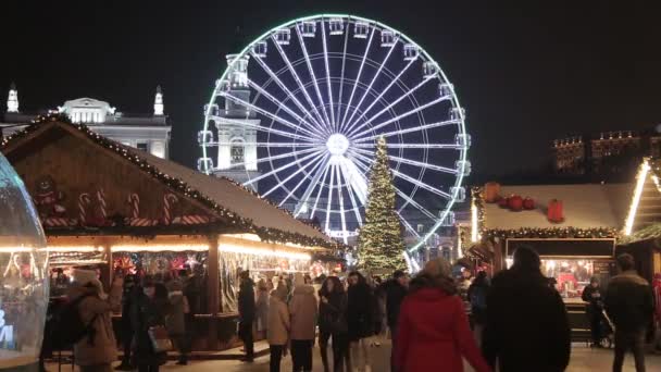 キエフ ウクライナだ 2022年1月 クリスマスマーケット 観覧車 お祭りのライトとクリスマスツリー 広場を歩く人々 — ストック動画