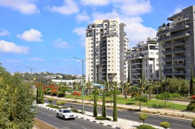 İsrail. Rishon LeZion Haziran 2022 Etrafı bahçeyle çevrili güzel bir ev. Modern konut. İsrail - yüksek binalar, çiçek açan ağaçlar. Konsept: yaşamak için güzel bir yer, gayrimenkul satın alma