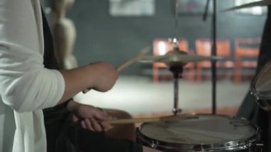 Davul seti. Davulcunun elleri yakın plan, adam bagetlerini tutuyor. Rock grubu provası, canlı performans, davul dersi..