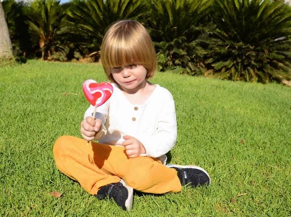 Porträt Eines Süßen Positiven Kleinen Jungen Mit Einem Herzförmigen Bonbon — Stockfoto