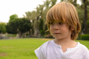 Portrait of a little boy. Child 3 years old, boy with long hair. place for text. Emotions on the face