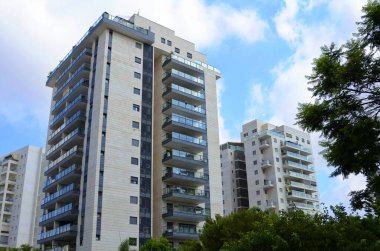 Beautiful residential building surrounded by a garden. Modern housing. Israel - high-rise building, flowering and palm trees. Concept: nice place to live, real estate purchase