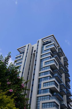 Beautiful residential building surrounded by a garden. Modern housing. Israel - high-rise building, flowering and palm trees. Concept: nice place to live, real estate purchase
