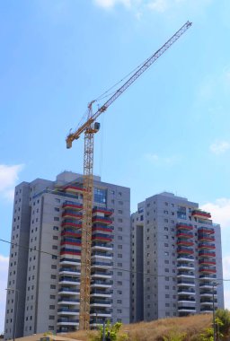 Construction of a residential building. Modern architecture. Construction crane and palm tree in the foreground. ISRAEL Rishon LeZion August 2022