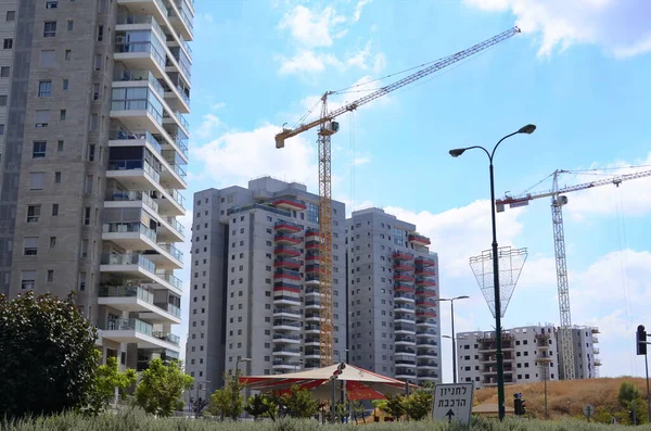 Construction of a residential building. Modern architecture. Construction crane and palm tree in the foreground. ISRAEL Rishon LeZion August 2022