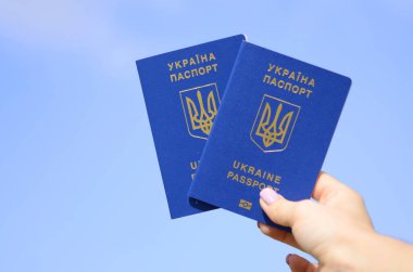 Passport of Ukraine. The hand holds a two  Ukrainian biometric foreign passport. Concept: travel, citizenship, emigration