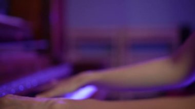 Woman Professional pianist hands playing on a wooden old grand piano close-up. Piano keys close up in dark violet colors. Student trains to play the piano Slow motion