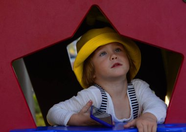 Oyuncak bir çocuğun evindeki küçük sevimli bir çocuk pencereden dışarı bakıyor. Çocuğun elinde bir cep telefonu var. Ebeveynlerle, arkadaşlarla, aileyle konsept bağlantısı.