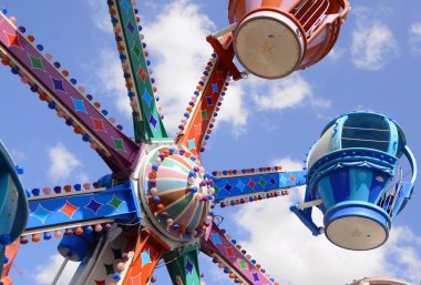 Klasik Luna Parkı, eski usul binişler. Atlıkarınca, çocuk treni, paraşütler, lunapark. Parlak resim - çocuklarla tatil. Metin için yer.