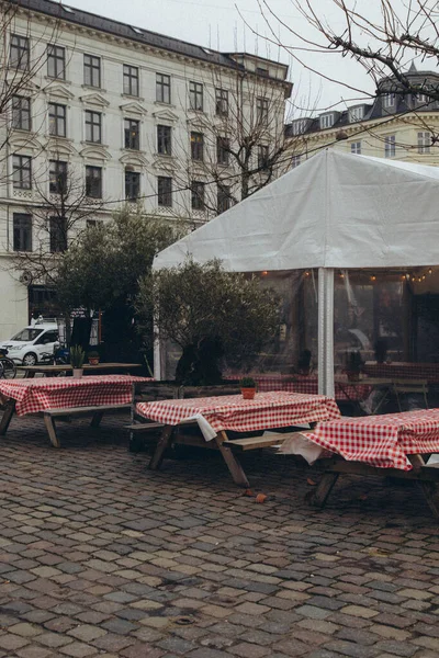 Beyaz Bir Çadırın Önünde Kırmızı Masa Örtüleri Ahşap Banklar Olan — Stok fotoğraf