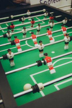 Futbol masası, siyah, beyaz, kırmızı ve beyaz formalı takımlar yeşil sahada dikey