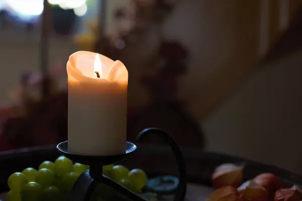 Closeup view of the candle on the table with fruit
