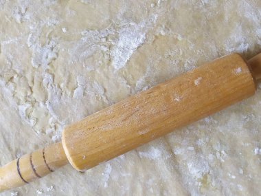 Ev yapımı hamurlar tahta bir oklavayla yuvarlanıyor.