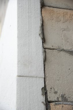 Sert strafor yalıtım levhası ile tuğla ev duvarının yakın çekim detayı. Modern inşaat, yenileme ve enerji tasarrufu teknolojisi. Mineral yün için alternatif, sıcak rahat ev konsepti