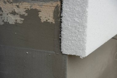 Sert stiroköpük yalıtım kağıdıyla bir ev duvarının yakın plan detayları.