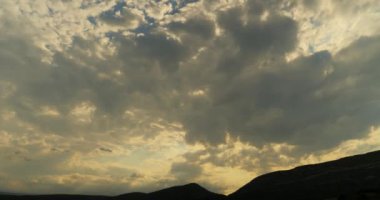 Gün batımında dağın tepesinde bulutlar hızlanır..