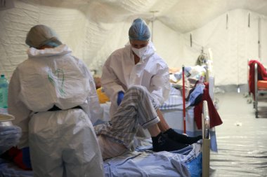 BUCHAREST, ROMANIA - 15 Ekim 2021: Kişisel Koruyucu Ekipman (PPE) giyen tıp çalışanları, Coronavirus Outbr yüzünden aşırı kalabalık olan St. Pantelimon hastanesinin acil servisinin bir uzantısı olan çadırdaki hastalara bakıyorlar