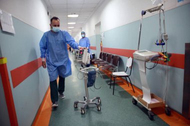 BUCHAREST, ROMANIA - 15 Ekim 2021: Kişisel Koruyucu Ekipman (PPE) giyen tıp çalışanları, Coronavirus salgını nedeniyle aşırı kalabalık olan St. Pantelimon hastanesinin acil servisinde hastalar için ekipman taşıyorlar.