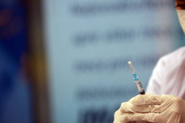 BUCHAREST, ROMANIA - 23 Ekim 2021 Bükreş 'teki Ulusal Kütüphane Aşılama Maratonu sırasında bir doz COVID 19 aşısı uygulayan bir tıp çalışanı.