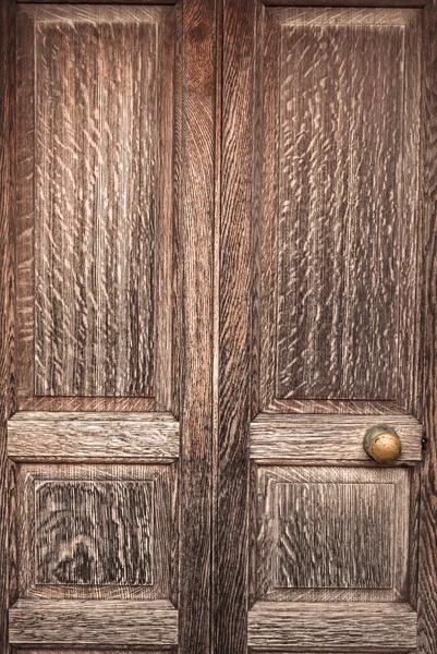 Old Panelled Wooden Door, faded and weathered, in need of maintenance, wooden bars, background with no people and copy space