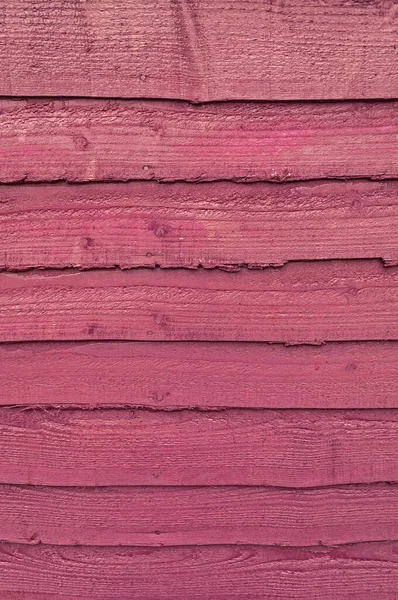 Coarse grained wooden boundary fence, knotted plum stained wood planking, full frame, wallpaper, background.