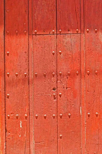 Kırmızı beyaz boyalı eski ahşap kapı.