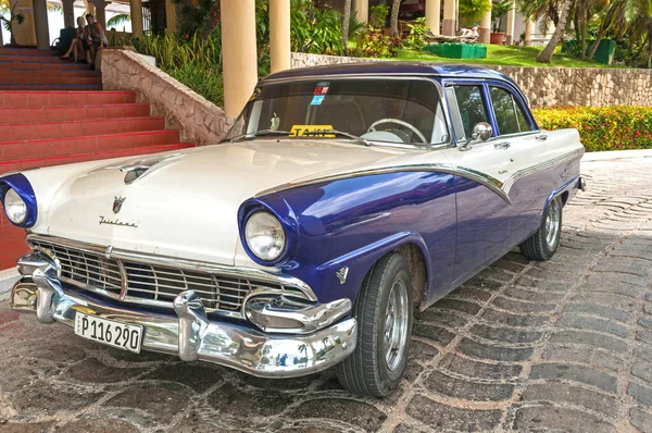 Kırmızı ve mavi renkli eski model bir araba.