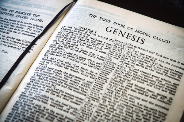 Закрытие страницы Священной Библии, низкая глубина поля с упором на заголовок главы книги, Генезис