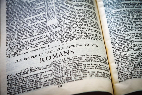 Close up of Holy Bible page, shallow depth of field with focus on book chapter heading, Romans